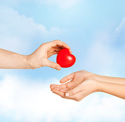 Image showing man hand giving red heart to woman