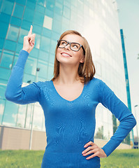 Image showing smiling woman pointing her finger up