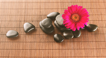 Image showing massage stones with flower on mat