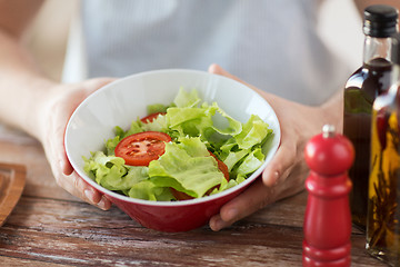 Image showing close of male hand holding a bowl with salad