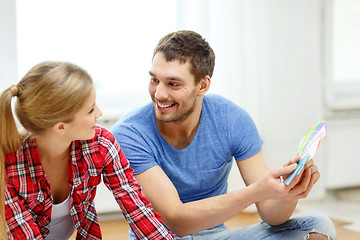 Image showing smiling couple looking at color samples at home