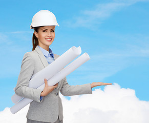 Image showing smiling architect in white helmet with blueprints