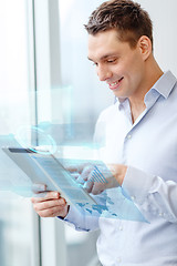 Image showing smiling businessman with tablet pc in office