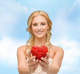 Image showing smiling woman giving small red heart