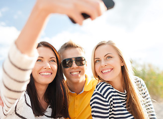 Image showing friends taking picture with smartphone camera