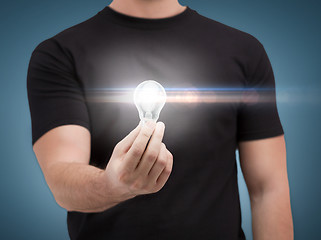 Image showing close up of man holding light bulb