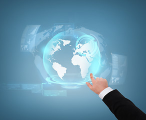 Image showing close up of businessman pointing to globe hologram