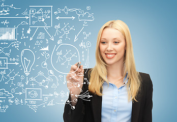 Image showing smiling businesswoman drawing big plan in the air