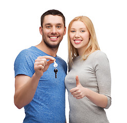 Image showing smiling couple holding keys and showing thumbs up