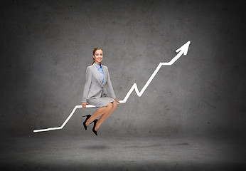 Image showing smiling businesswoman sitting on chart