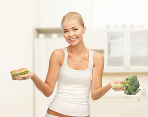 Image showing smiling woman with broccoli and hamburger