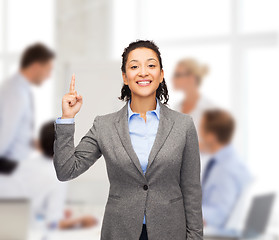 Image showing smiling businesswoman with her finger up at office