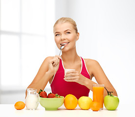 Image showing young woman eating healthy breakfast