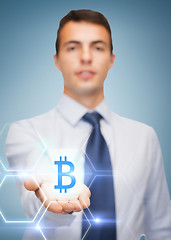 Image showing friendly buisnessman showing bit coin on the palm