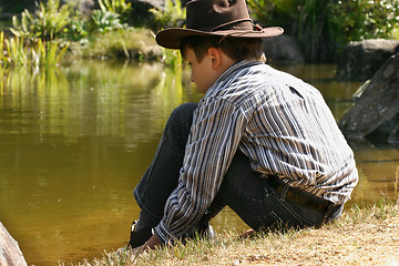 Image showing Child sitting by outback billabong