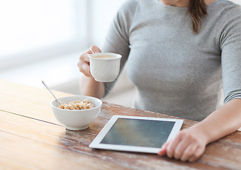 Image showing woman drinking coffee and using tablet pc