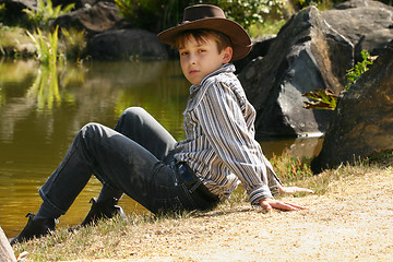 Image showing Rural boy sitting by banks of a river