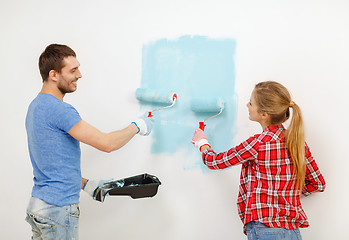 Image showing smiling couple painting wall at home