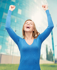 Image showing laughing young woman with hands up