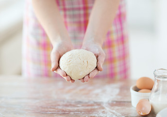 Image showing close up of female hands holding bread dough