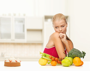 Image showing doubting woman with fruits and pie