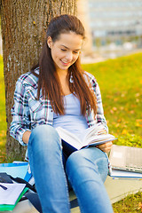 Image showing smiling teenager reading book