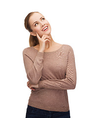 Image showing smiling woman dreaming over white background