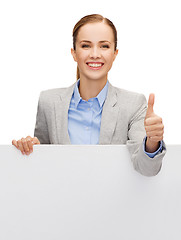 Image showing smiling businesswoman with white blank board