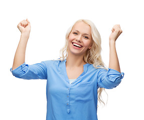 Image showing smiling young woman with hands up