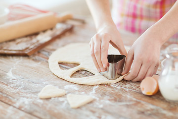 Image showing close up of hands making cookies from fresh dough