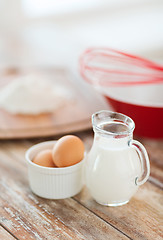 Image showing jugful of milk, eggs in a bowl and flour