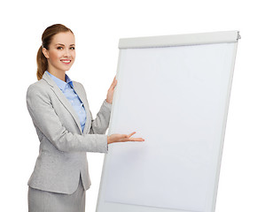 Image showing smiling businesswoman standing next to flipboard