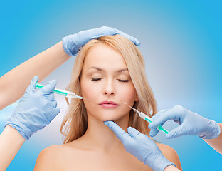 Image showing woman face and beautician hands with syringes