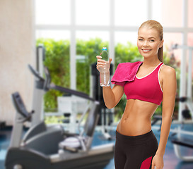 Image showing smiling woman with bottle of water at gym