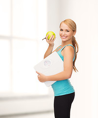 Image showing sporty woman with scale and green apple