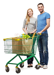 Image showing smiling couple with shopping cart and food in it