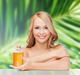 Image showing happy woman with oil bottle