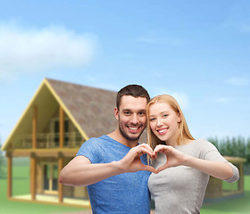 Image showing smiling couple showing heart with hands