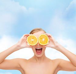 Image showing amazed young woman with orange slices