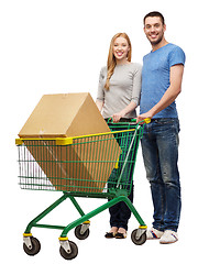 Image showing smiling couple with shopping cart and big box