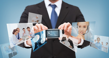 Image showing businessman with smartphone and news on screen