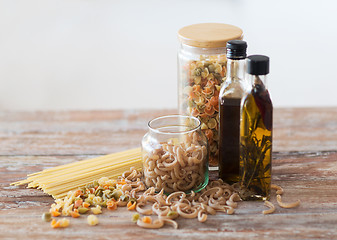 Image showing close up of two olive oil bottles and pasta in jar