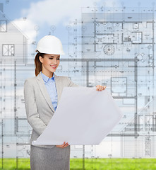 Image showing smiling architect in white helmet with blueprints