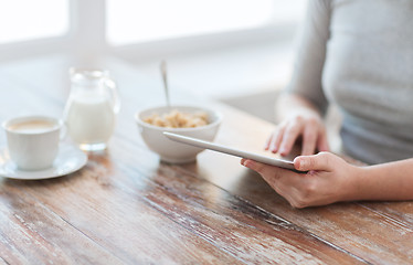 Image showing close up of woman reading news from tablet pc