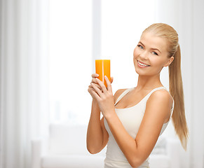 Image showing smiling woman holding glass of orange juice