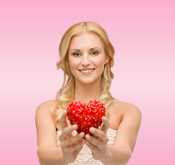 Image showing smiling woman giving small red heart