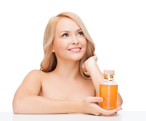 Image showing happy woman with oil bottle