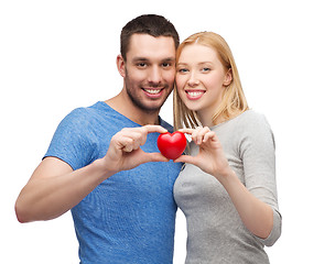 Image showing smiling couple holding small red heart