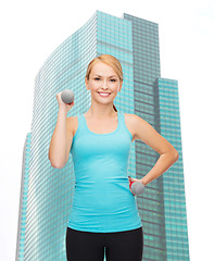 Image showing young sporty woman with light dumbbells