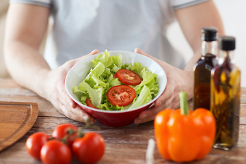 Image showing close of male hand holding a bowl with salad